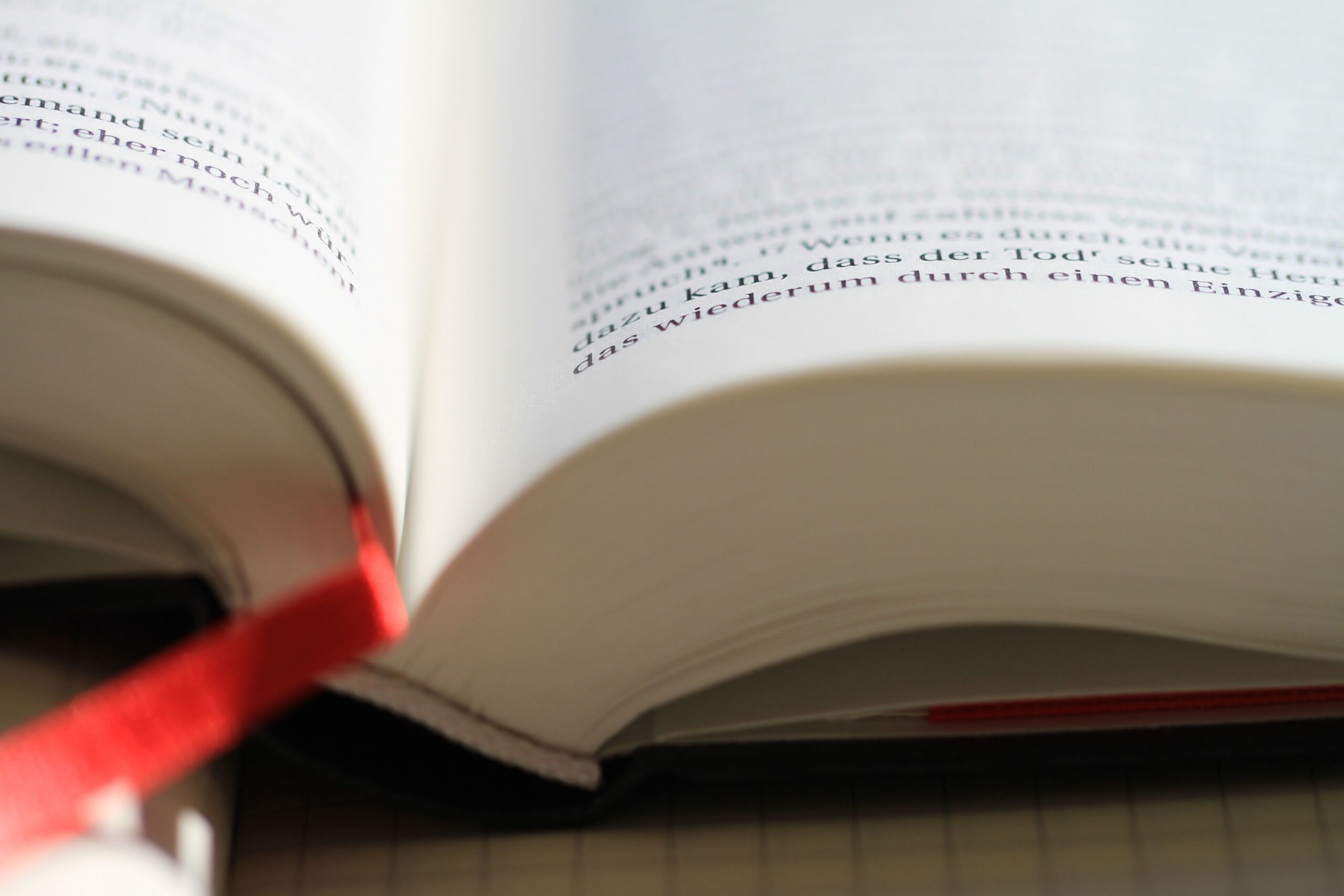Libro abierto con señalador rojo, fotografía ilustrativa sobre la lectura